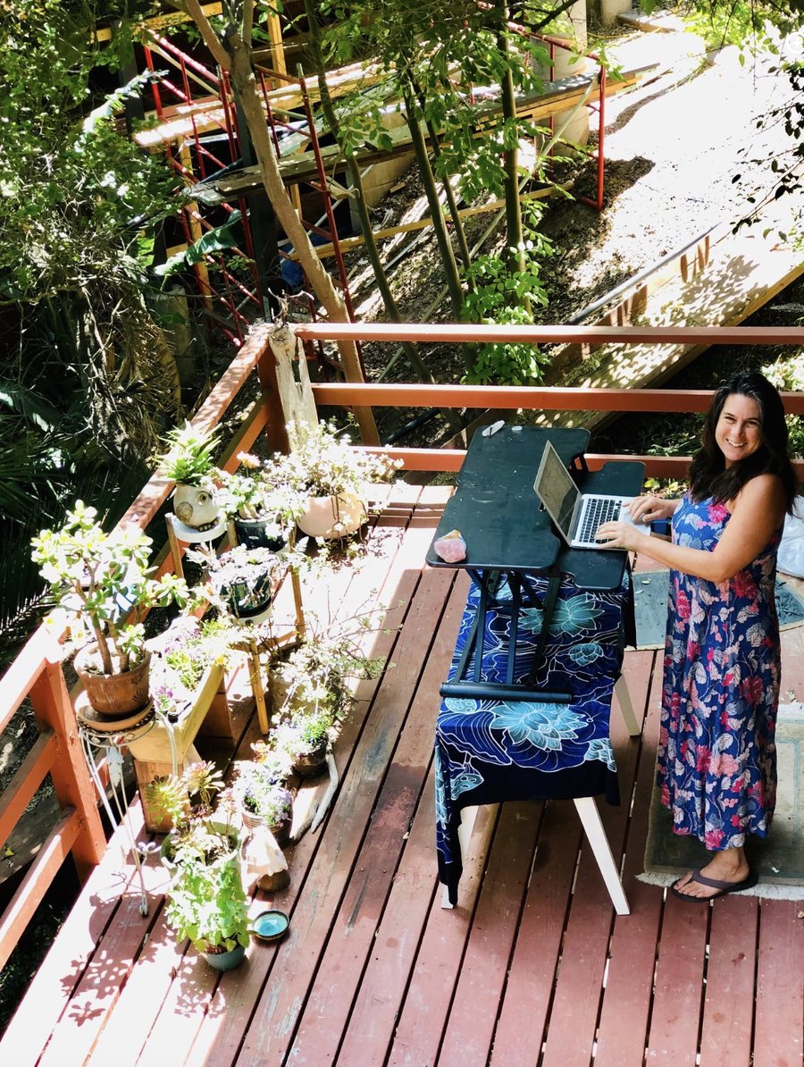 Leah working outdoors on her deck, surrounded by plants