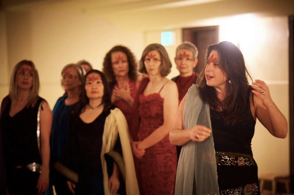 A procession of women with red markings on their foreheads